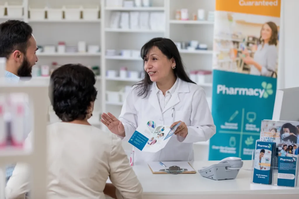 Frau berät zwei Kunden in einer Apotheke vor Ort