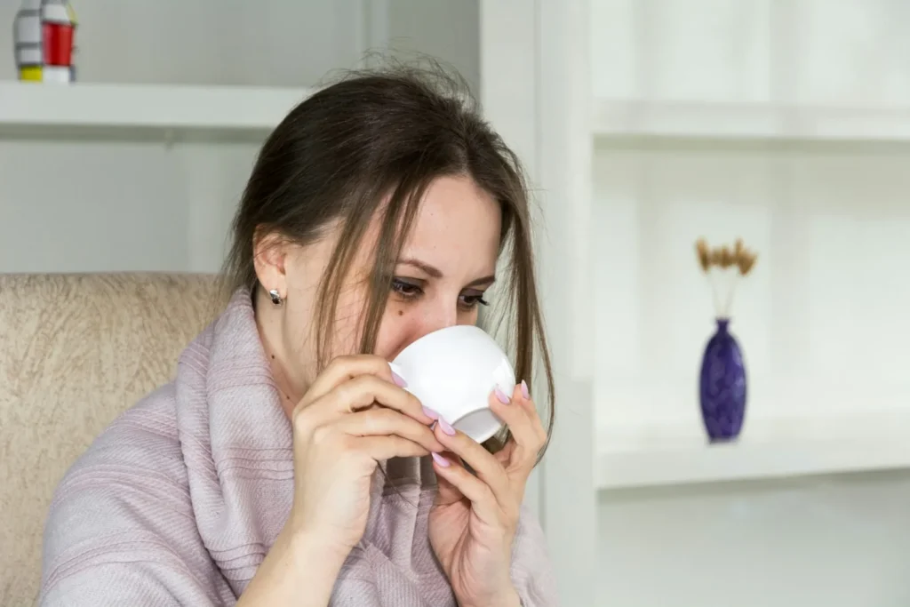 Erkältung - Frau trinkt eine Tasse warmen Tee